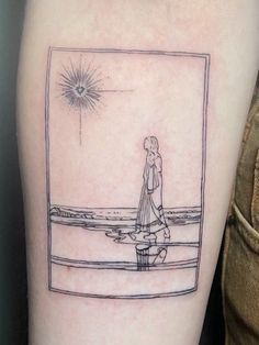 a person with a tattoo on their arm is standing in front of a window and looking at the sky