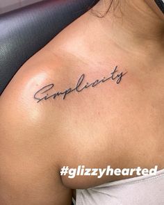 a woman with a tattoo on her shoulder that says complicity in cursive writing