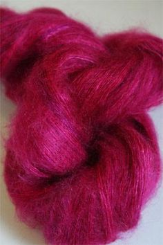 a skein of pink yarn sitting on top of a white surface