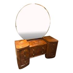 a mirror sitting on top of a dresser next to a wooden table with drawers and drawers