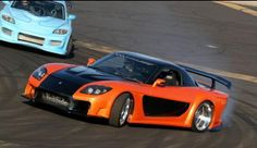 two orange and black sports cars driving on a track