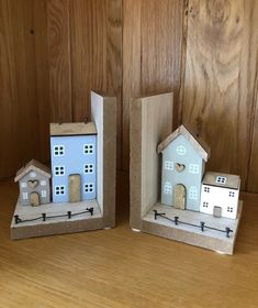 two small wooden houses sitting on top of a table