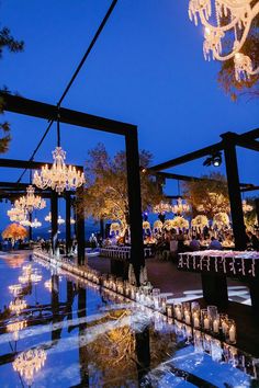 an outdoor dining area with chandeliers and tables set up for a formal function