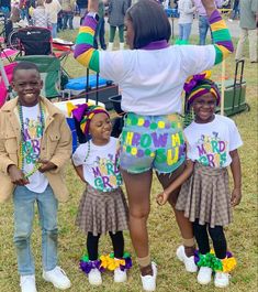 a group of children standing next to each other in front of a crowd at an outdoor event