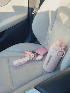 a bottle, toothbrush and other items sit on the back seat of a car