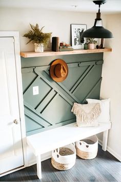 a white bench sitting under a wooden shelf with hats on it's head and two baskets next to it