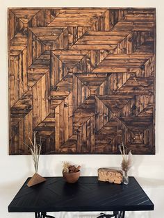 a table with two vases on it next to a large wood paneled wall