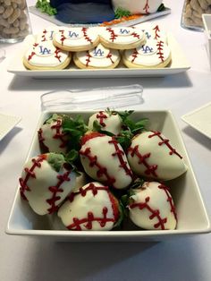 some cookies and other desserts on a table with white plates filled with strawberries