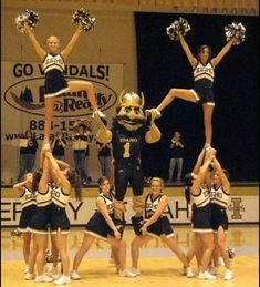 a group of cheerleaders are performing on the stage with their hands in the air