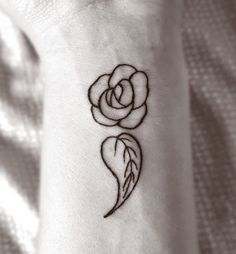 a small rose tattoo on the wrist