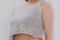 a close up of a woman wearing a crochet top