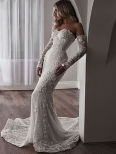 a woman in a white wedding dress is posing for the camera with her hands on her hips