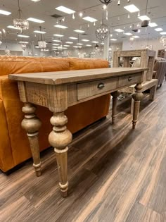 a large wooden table sitting in the middle of a living room next to a couch