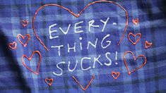 the words every thing sucks written on a blue plaid shirt