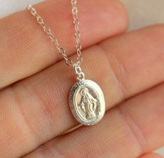 "This is a lovely little Miraculous charm necklace made of 14kt gold filled. This sacred oval pendant is 14kt gold filled, measures 14x9mm and comes on a 14kt gold filled chain with spring clasp. Choose length of 16\", 18\", 20\" or 22\". Comes in a cute gift box ready to present. *Model is wearing a 18\" length in the photo. *May be ordered and gold filled, rose gold filled or sterling silver." Dainty Oval Sterling Silver Charm Necklaces, Dainty Miraculous Medal Charm Necklaces As Gifts, Dainty Miraculous Medal Charm Necklace As Gift, Dainty Charm Necklaces With Miraculous Medal For Gifts, Dainty Charm Necklaces With Miraculous Medal As Gift, Oval Miraculous Medal Necklace As Gift, 14kt Gold Jewelry, Simple Necklaces, Virgin Mary Pendant