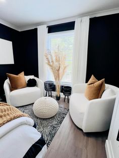 a living room with black walls and white furniture