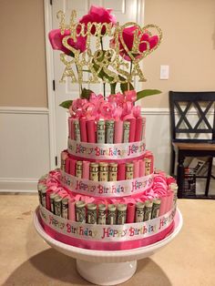 a birthday cake made out of stacks of money and pink roses