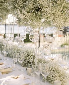 the table is set up with white flowers and wine glasses for an elegant wedding reception