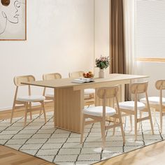 a dining table with four chairs and a potted plant on the top, in front of a window