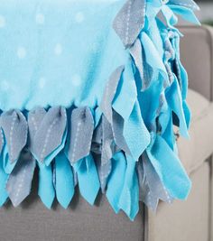 a blue and gray blanket sitting on top of a couch