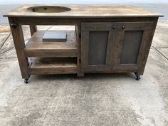 an old wooden table with a sink on it's top and wheels around the base