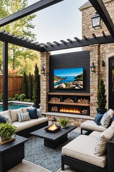 an outdoor living area with couches, tables and a television on the wall above