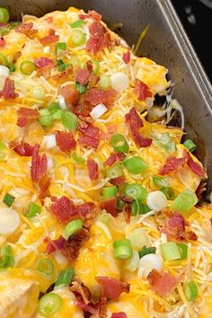 a casserole dish with bacon, green onions and cheese on it in a pan