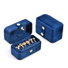 two blue velvet jewelry boxes with gold rings in them, one opened and the other closed