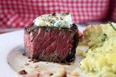 a piece of steak and mashed potatoes on a plate