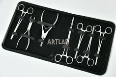 a black case filled with lots of different types of scissors on top of a white table