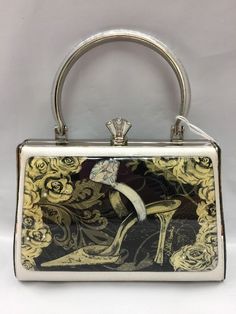 Debbie Brooks Brand New Evening Bag with handle  Black and White  Graphic print of a DIAMOND RING AND SHOE Surrounded by flowers Has Crystal embellishments Silver frame  Silver sparkly leather  Pretty silver under lucite on the handle  Has an additional long snake strap (Silver Tone) And comes with a dust bag Approximate Measurements  7” width 4.50" (not including lock) 2.5" depth Please email me with any questions or for more pictures before bidding All my items come from a smoke/pet free home Elegant Box Bag With Handle Drop For Gifts, Elegant Box Bag With Handle Drop As A Gift, Rectangular Clutch With Handle Drop For Shopping, Diamond Shoes, Long Snake, Silver Handbag, Surrounded By Flowers, Vintage Purses, Bag Handle