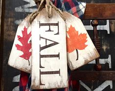 a wooden sign hanging on the side of a door with a canadian flag and maple leaves painted on it