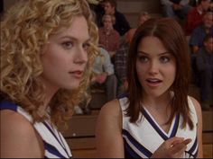 two young women in cheerleader outfits standing next to each other