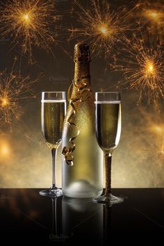 champagne bottle and two glasses with fireworks in the background