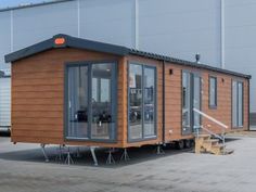 a tiny house sitting in the middle of a parking lot with stairs leading up to it