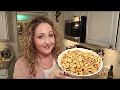 a woman holding up a bowl full of food