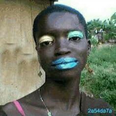 a woman with blue and yellow makeup is posing for a photo in front of a house