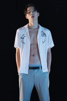 a man with no shirt on standing in front of a black background wearing blue pants