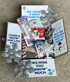 an open christmas gift box on the floor with snowflakes and greeting cards in it