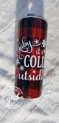 a red and black plaid tumbler with white writing on it that says boy, it's cold outside