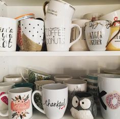 many coffee mugs are lined up on the shelf