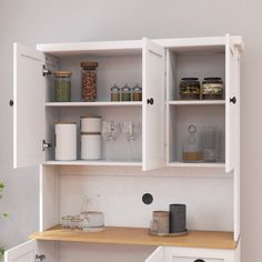 an open cabinet with wine glasses and other items on the shelves in front of it