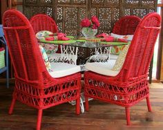 two red wicker chairs sitting at a table