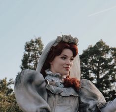 a close up of a person wearing a wedding dress and holding something in her hand