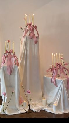 the table is covered with white cloths and pink flowers, which are adorned with candles