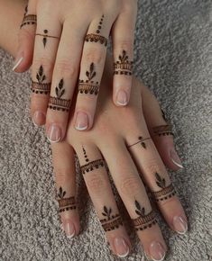 two hands with henna tattoos on their fingers