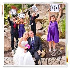 a group of people holding up signs in front of a rock wall with the words new bride and groom written on them