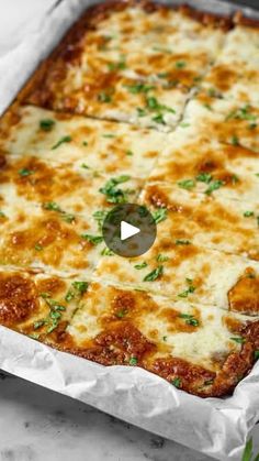 a square casserole dish with cheese and parsley