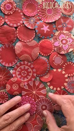 someone is making paper flowers out of red and pink circles on a table with the words,