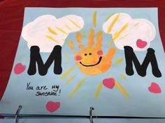 a child's handprint with the word mom on it and hearts around it